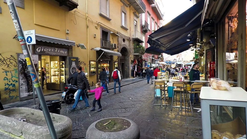 Busy street life in Naples with locals and tourists