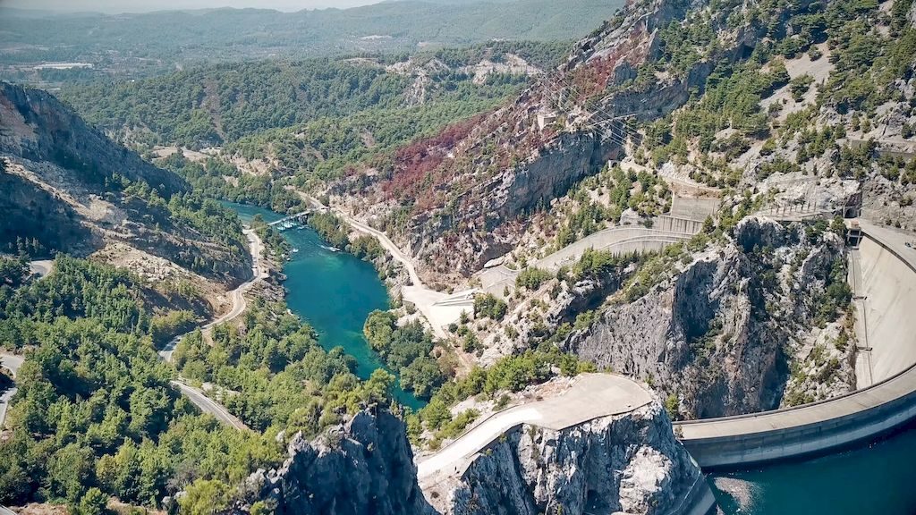 Panoramic view from Oymapinar Dam showing turquoise water and green mountains