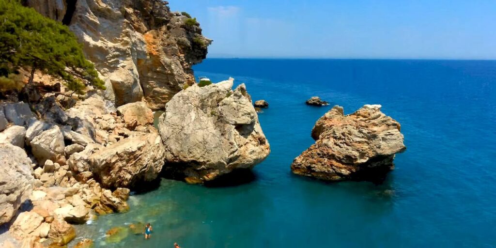 Wild beach of Beldibi with picturesque cliffs and pine forest