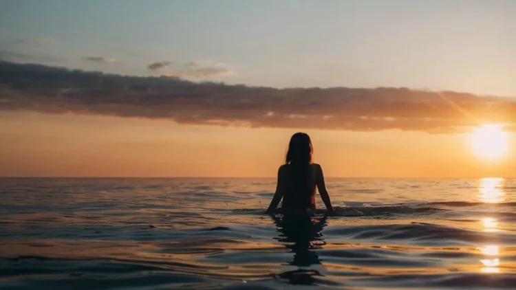Woman in the sea at sunset
