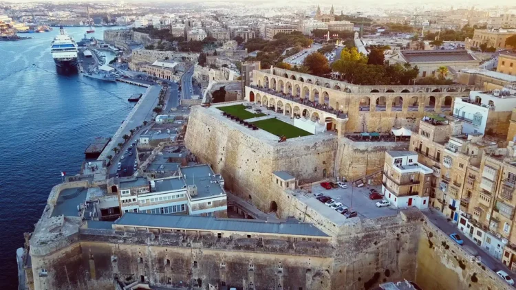 Vibrant Valletta Waterfront at sunset, with restored warehouses now housing restaurants and shops