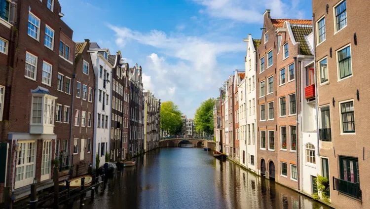 Beautiful Amsterdam canal with historic Dutch architecture and houseboats