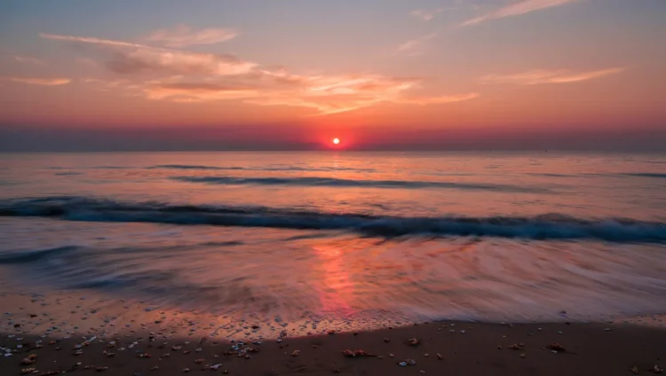 Sun setting below the horizon with glowing sky