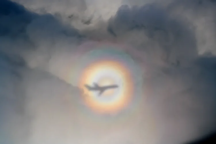 Glory optical phenomenon showing rainbow rings around shadow on clouds