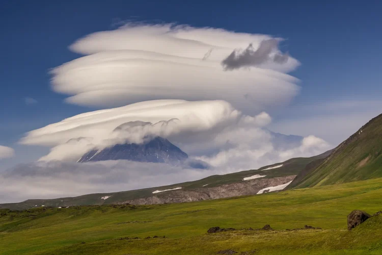 Lenticular clouds formation over mountains resembling UFO shapes