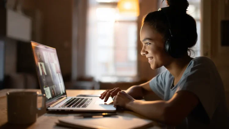 Young woman studying Thai language online with headphones and laptop